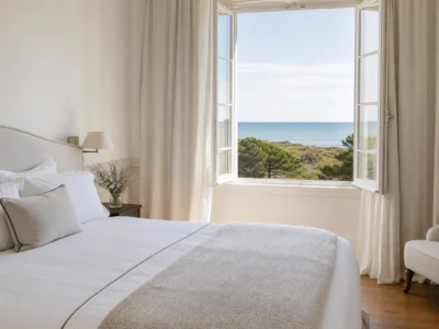 Chambre soignée d'une location saisonnière avec linge de lit blanc impeccable